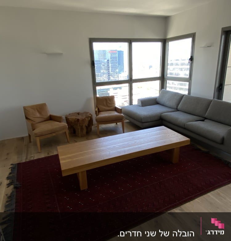 חדר עם ספה, כורסאות ושולחן עץ על שטיח אדום